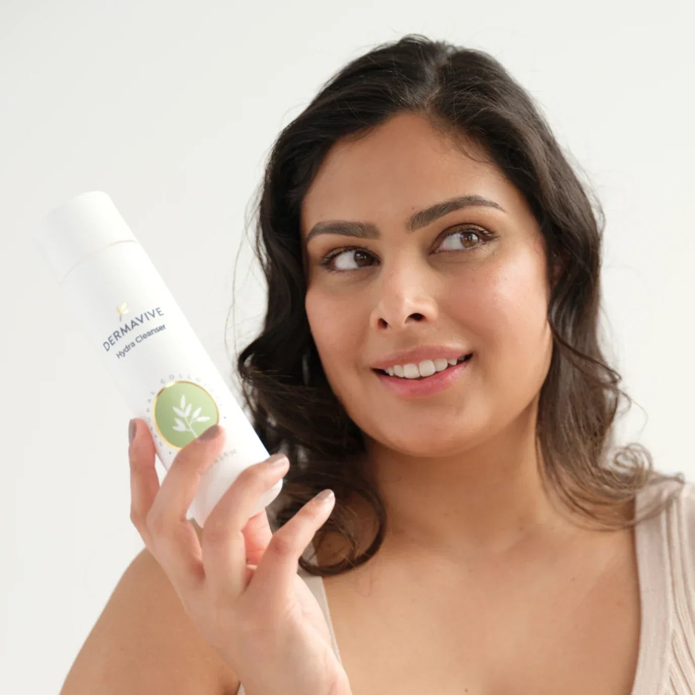 Model holding a cleanser from the natural skincare products Australia collection with a bright smile